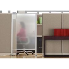 A person is sitting at a desk in a cubicle behind a frosted glass door.