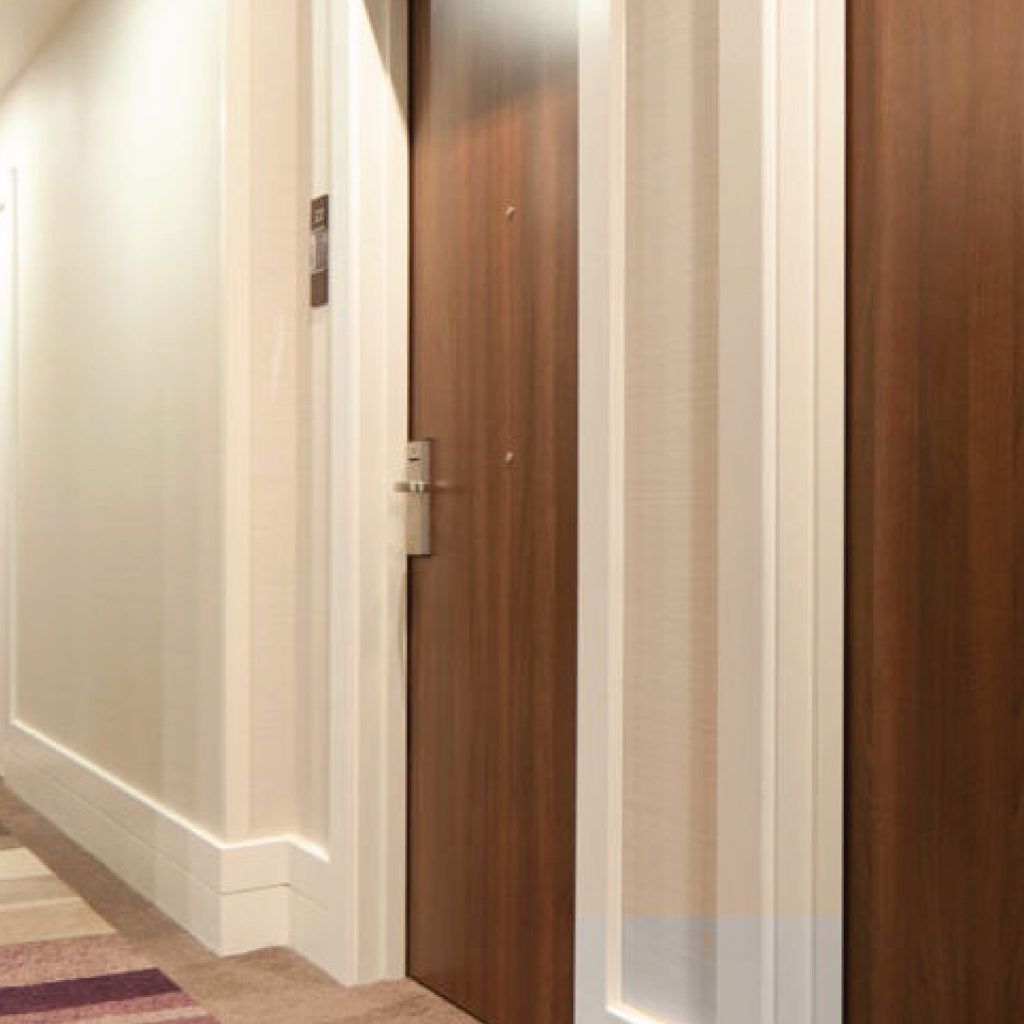 A hallway with a wooden door and white trim