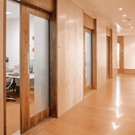A long hallway with sliding glass doors and a desk in the middle.
