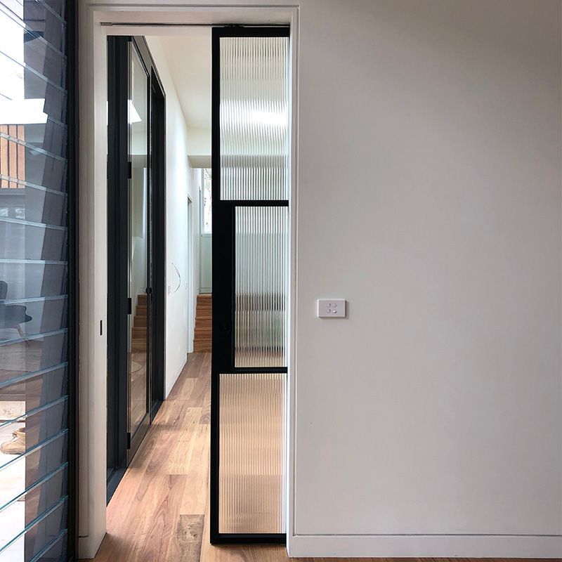 A hallway with a sliding glass door leading to a room.