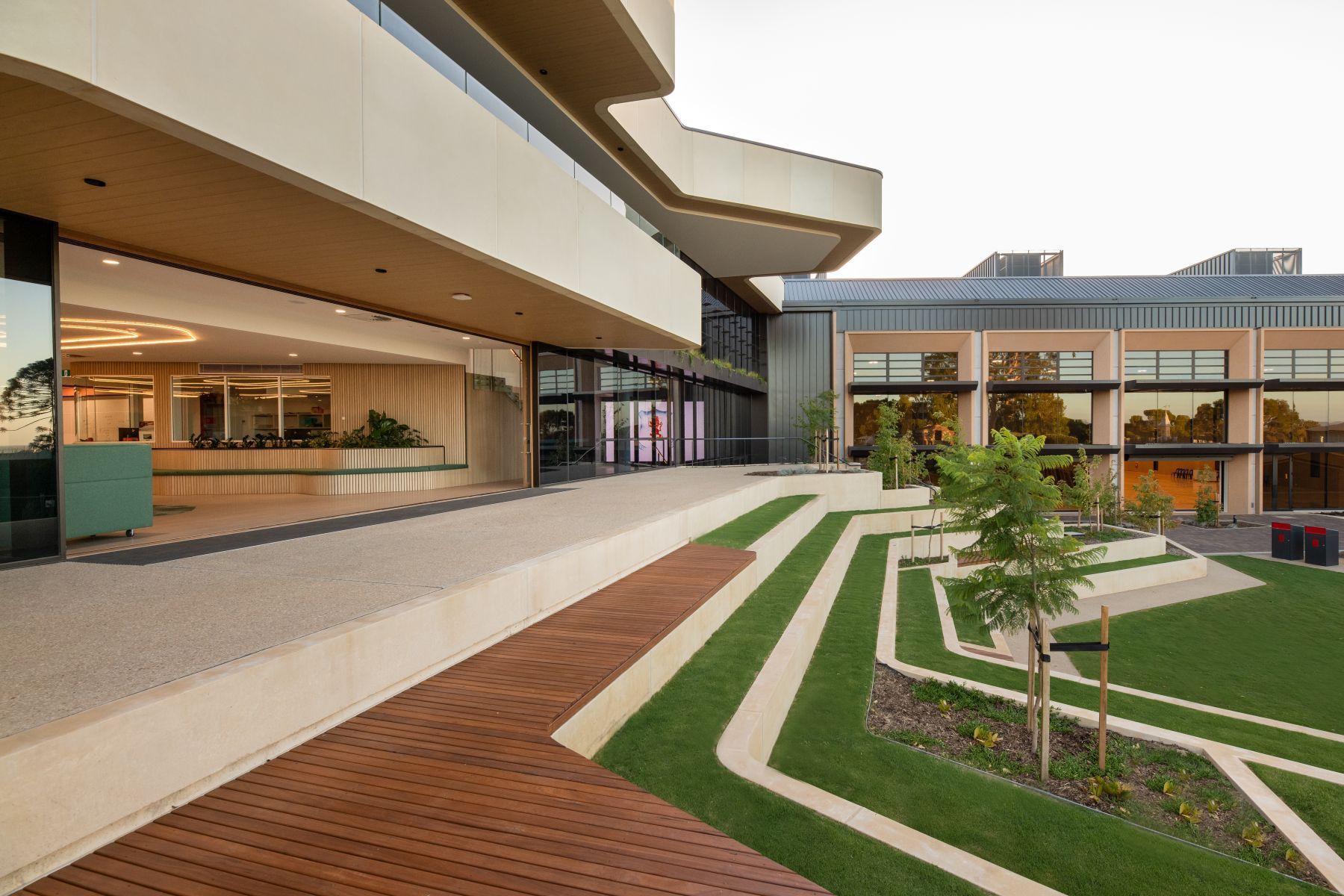 A large building with a lot of windows and a brick walkway in front of it.