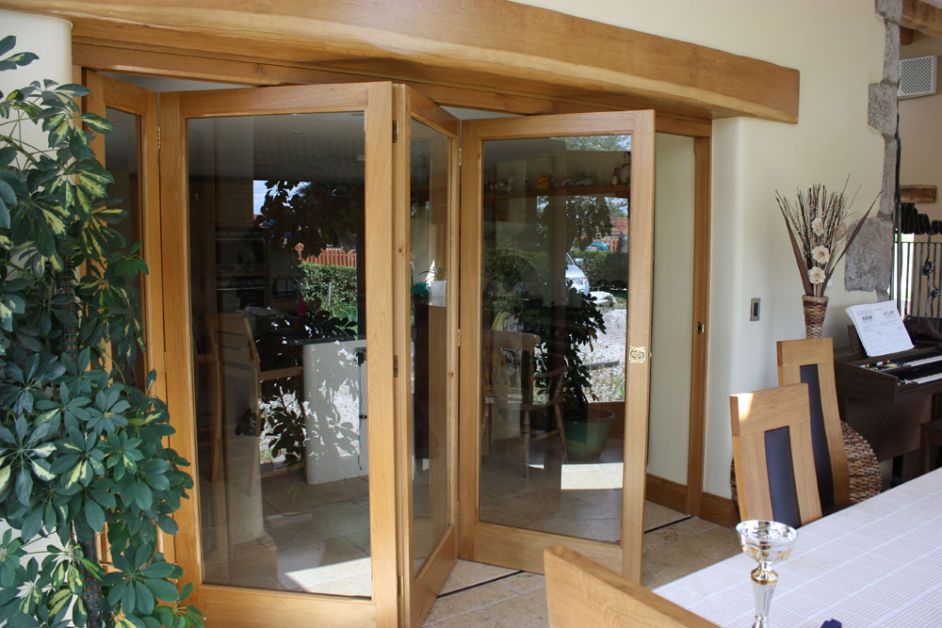A dining room with a table and chairs and a piano.