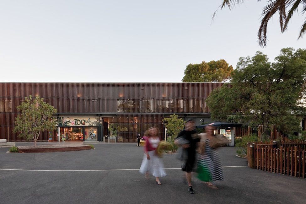 A group of people are walking in front of a building.