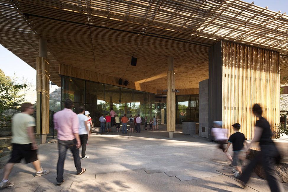 A group of people are walking in front of a building.