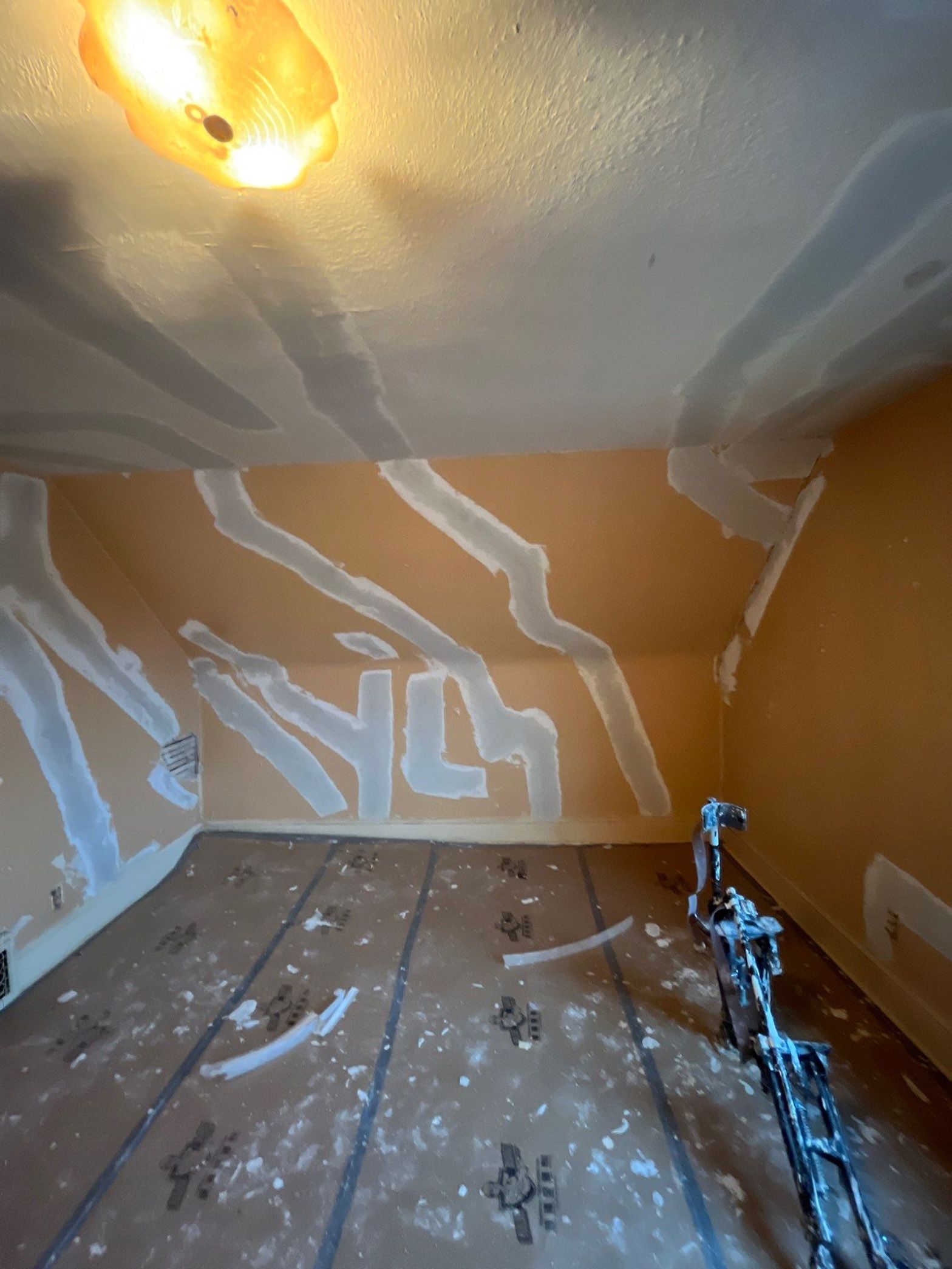 A room with a ceiling that is being painted.