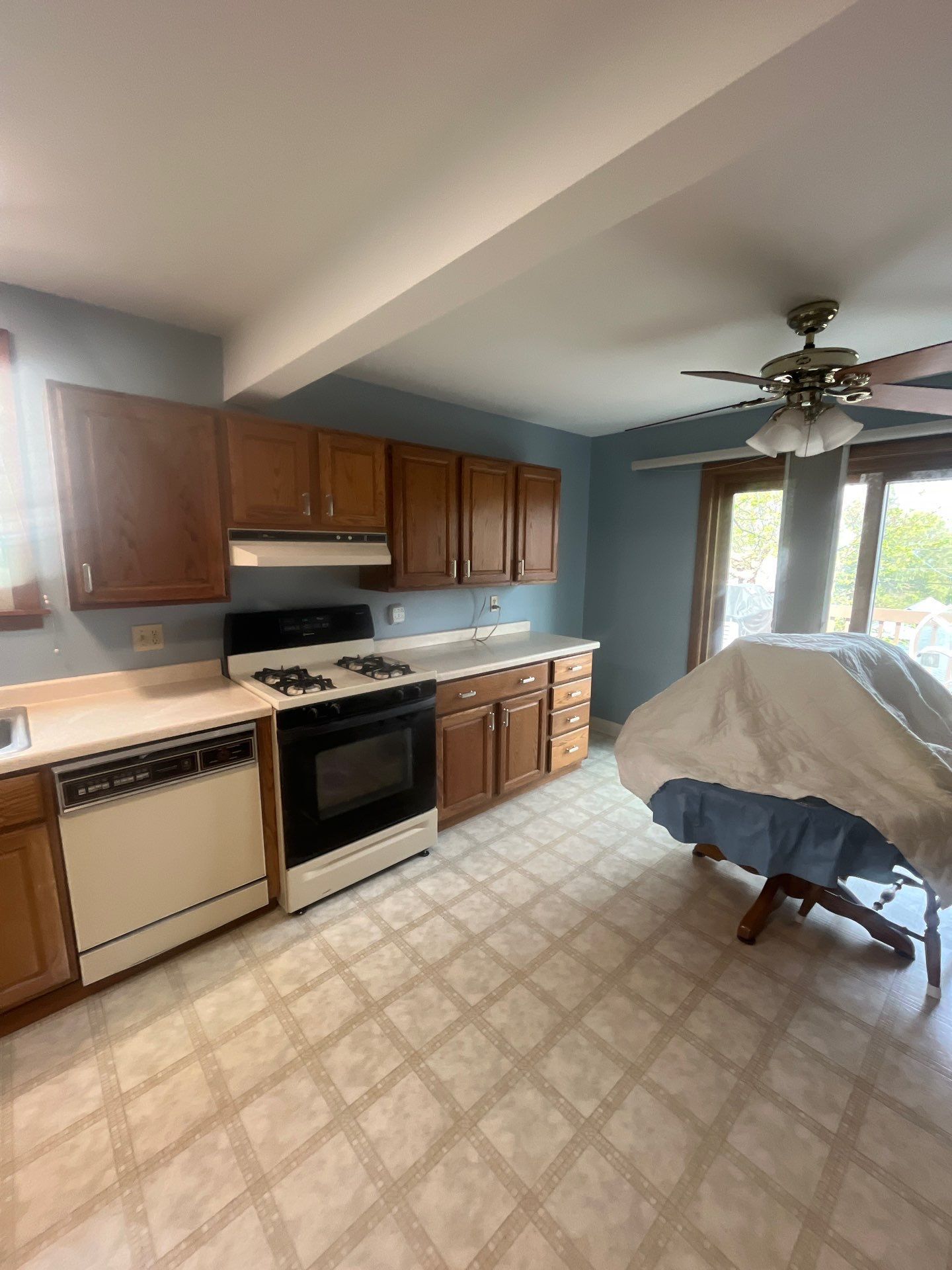 A kitchen with a stove , dishwasher , and ceiling fan.