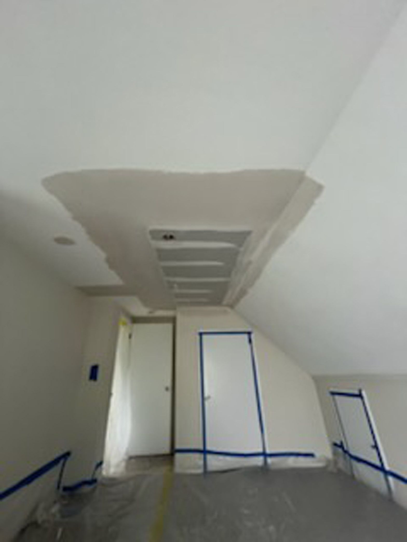 A room with a slanted ceiling and a door