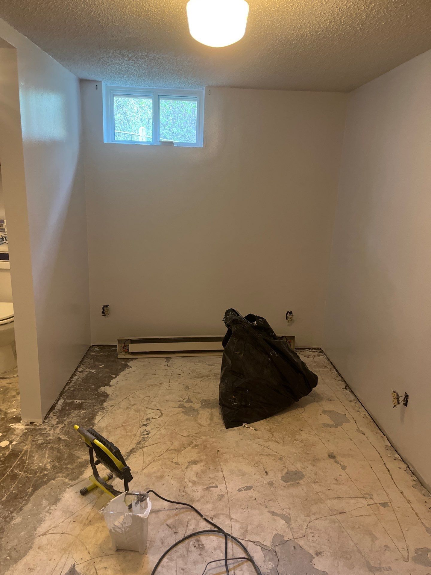 A room with white walls and a bag on the floor.