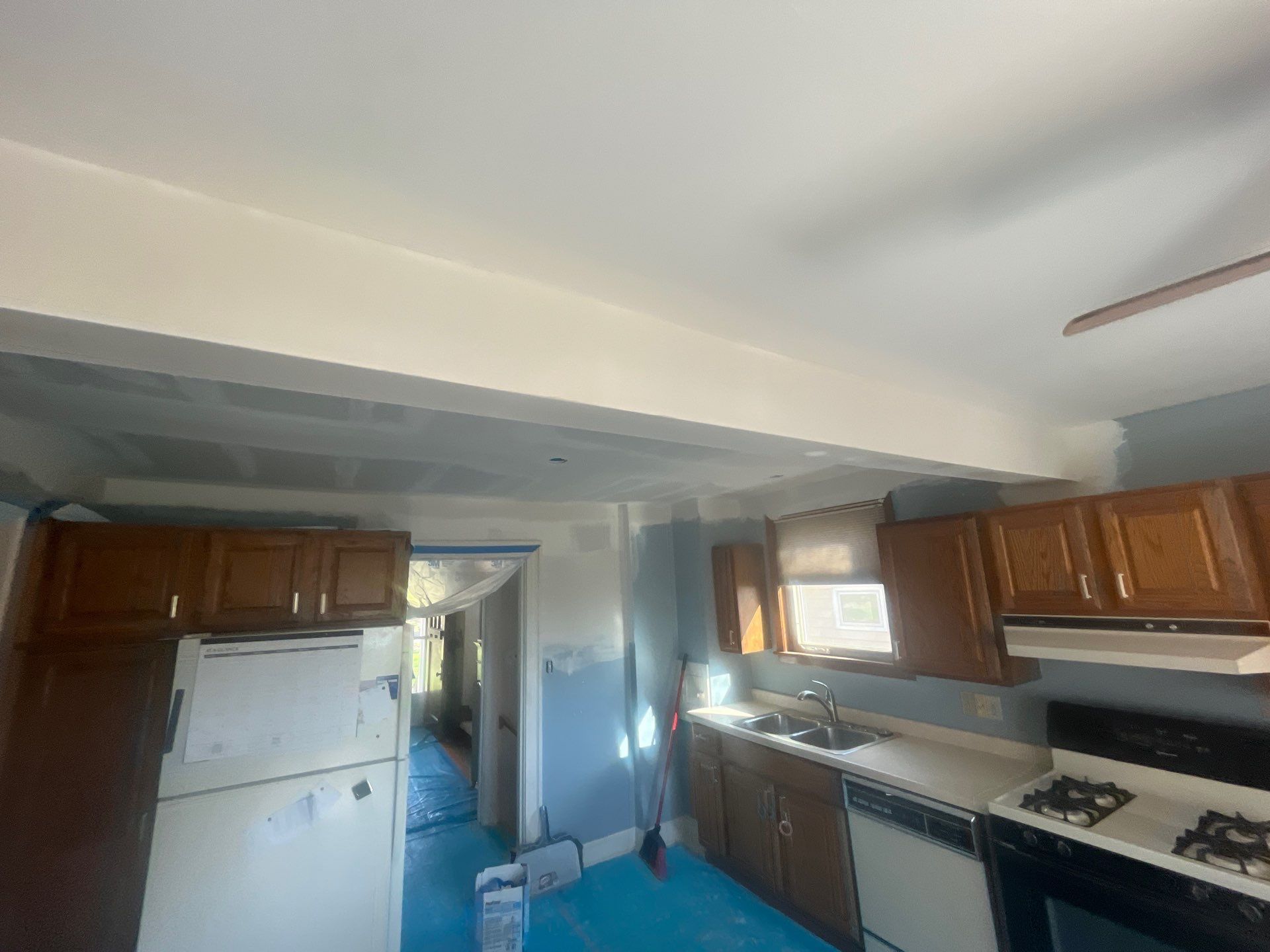 A kitchen with wooden cabinets , a refrigerator , a stove , and a sink.