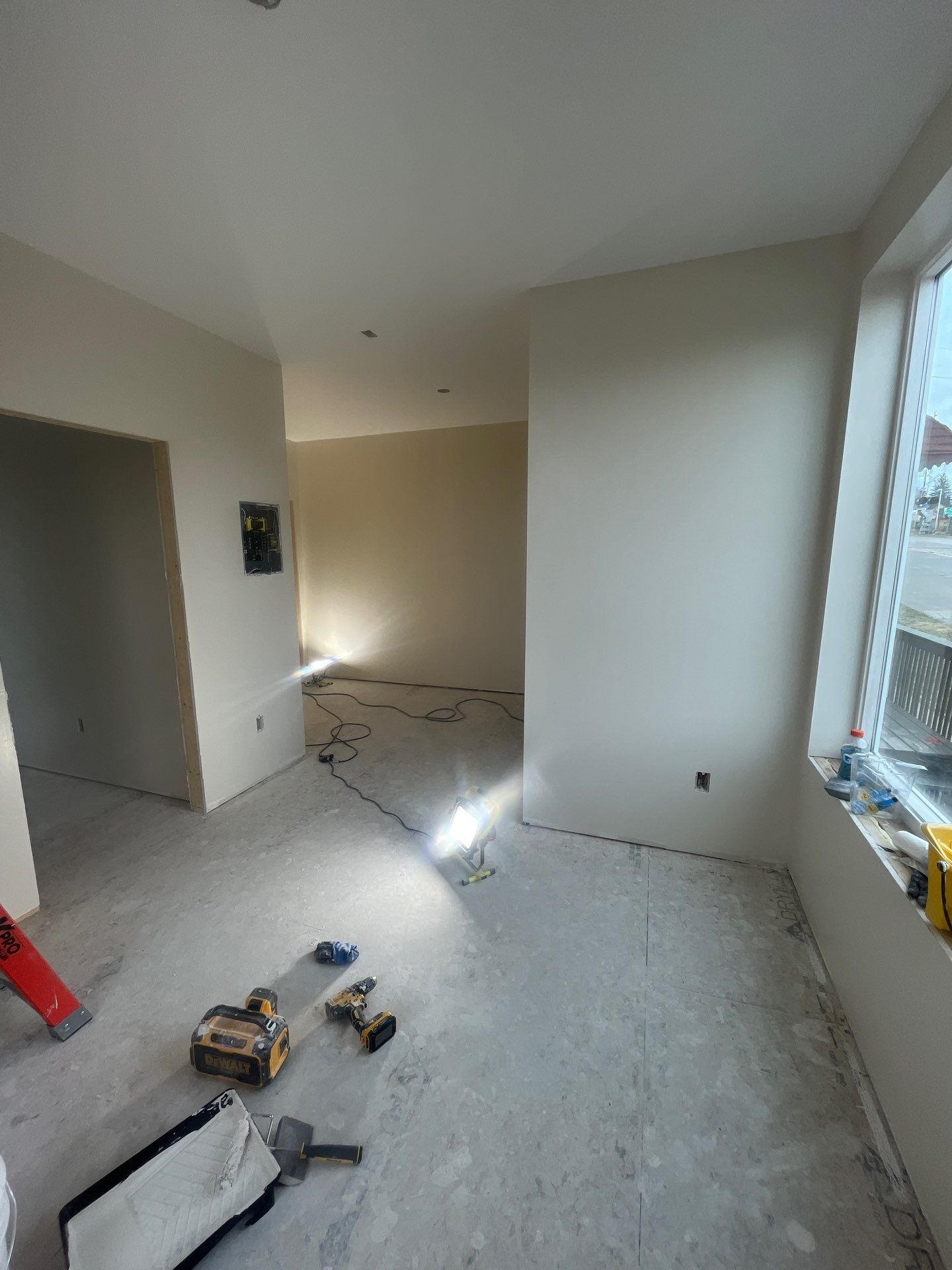 A room with a lot of white walls and a window.