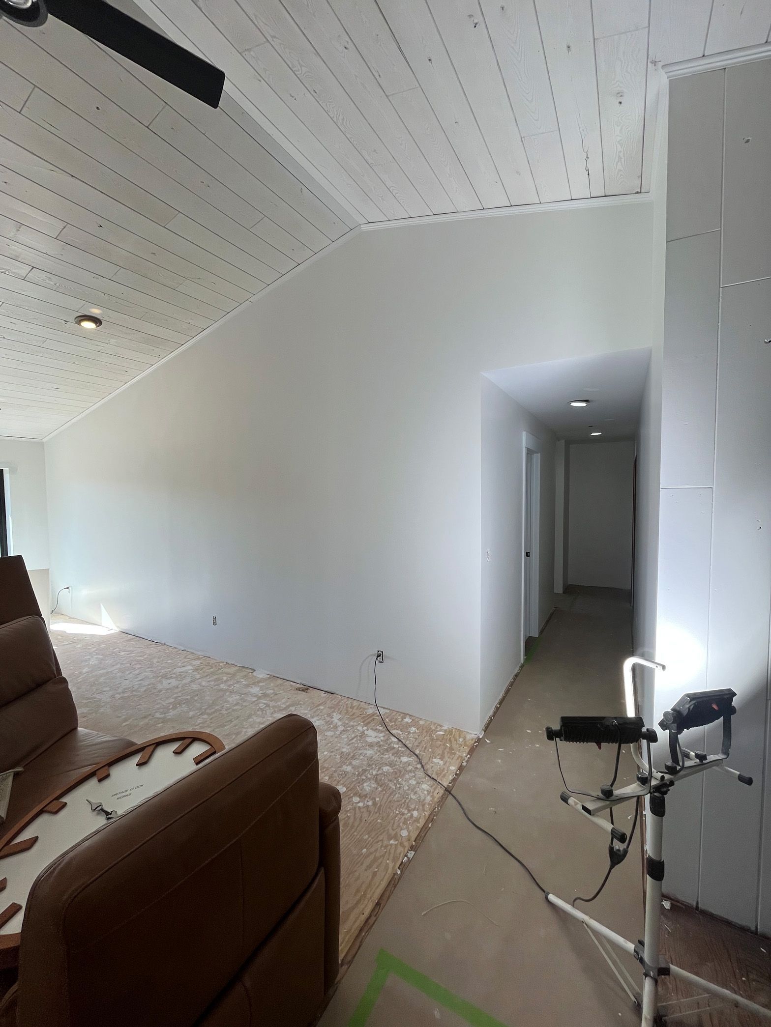 A living room with a brown couch and a white wall