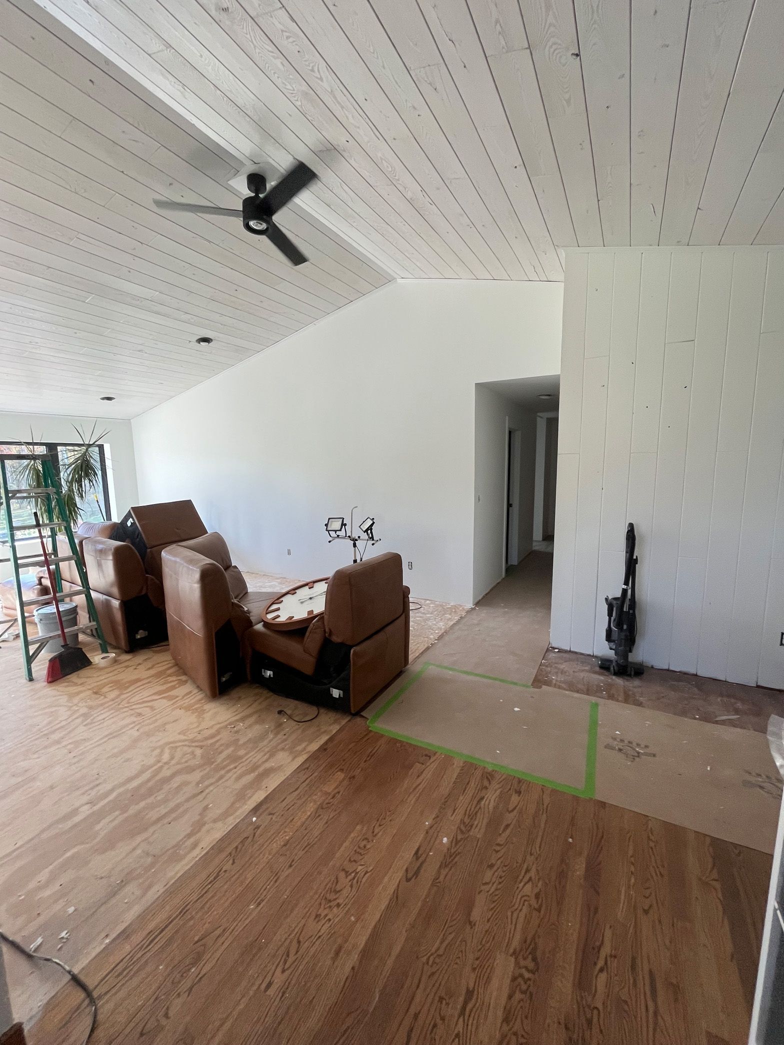 A living room with hardwood floors and a ceiling fan.