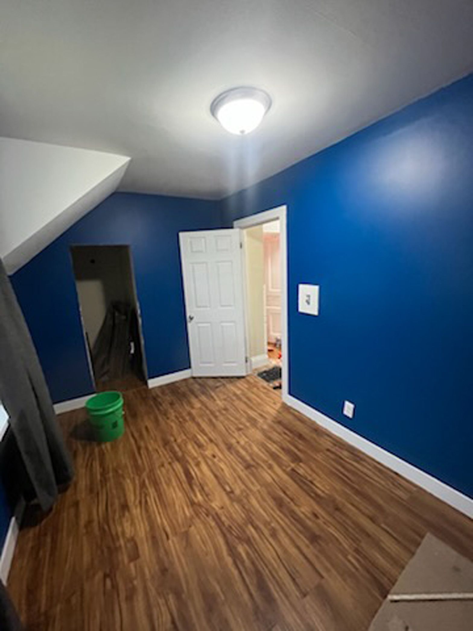 There is a green bucket in the middle of the room.