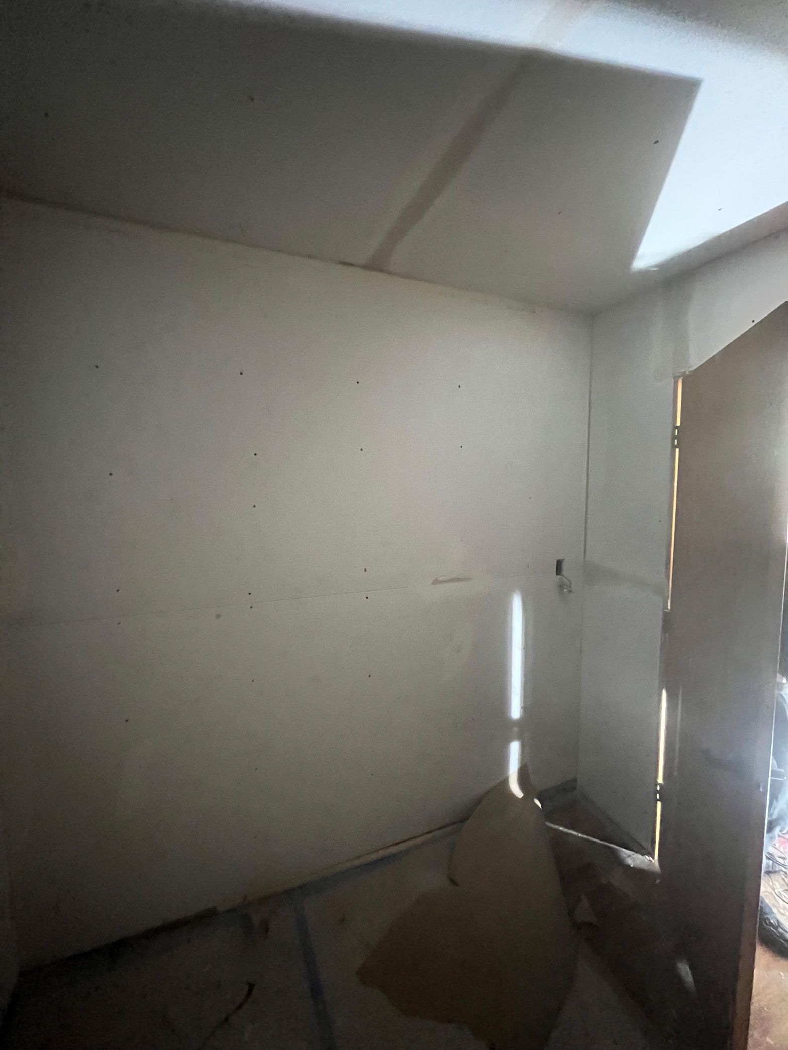 A room with a white wall and a window.