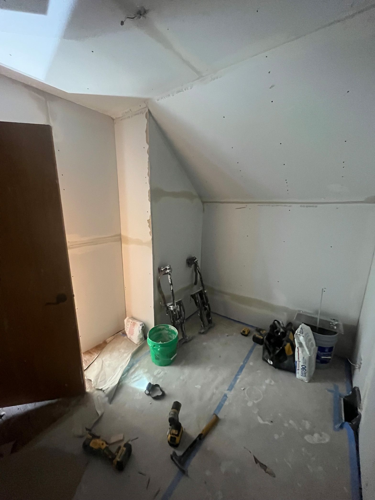 A room with a bicycle and tools on the floor.