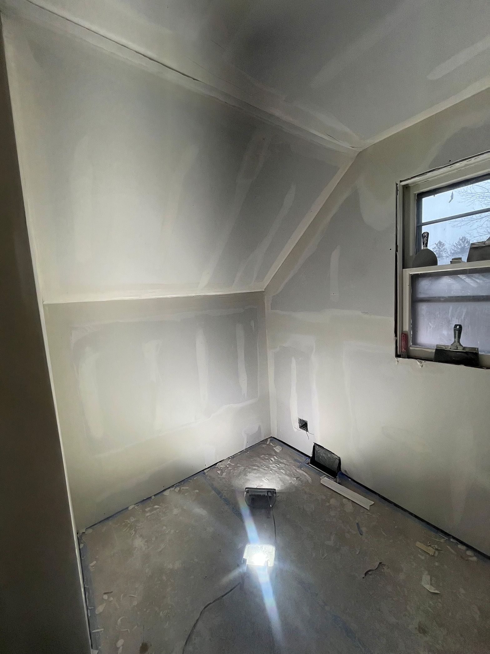 A room with a window and a ceiling that is being remodeled.