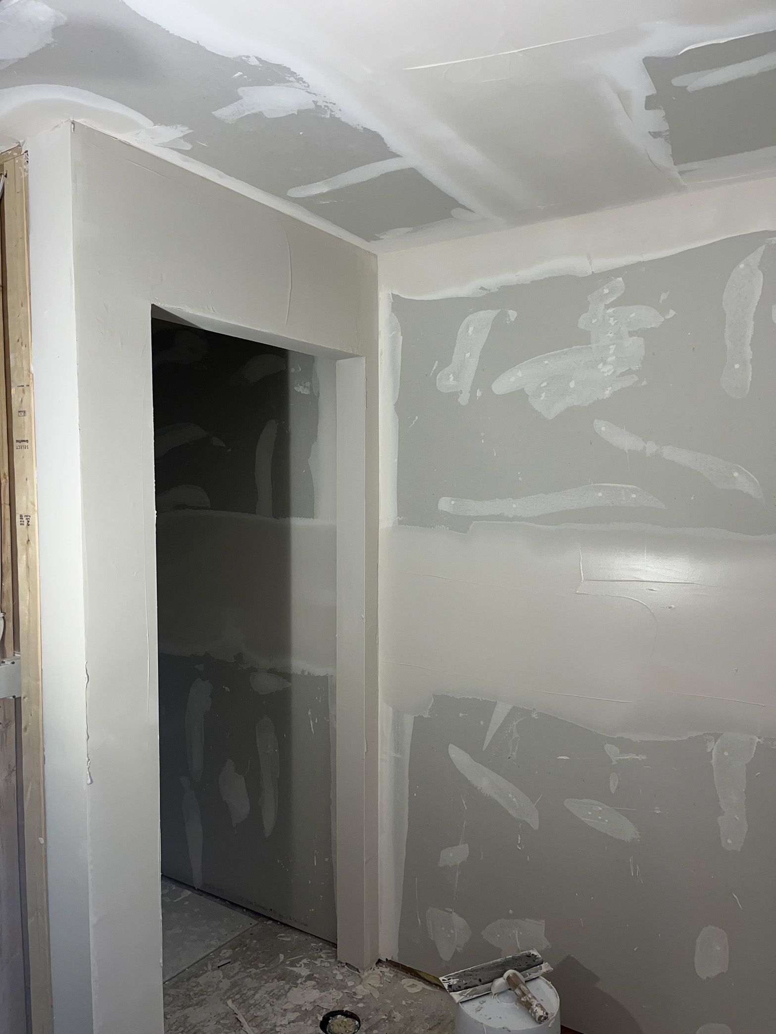 A room with drywall walls and a door.