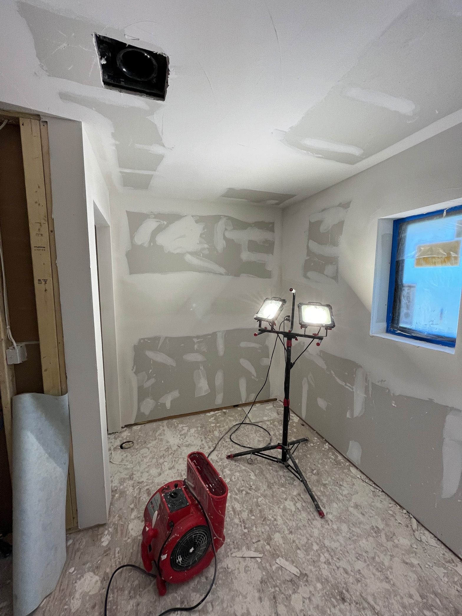 A room with a fan and two lights in it.