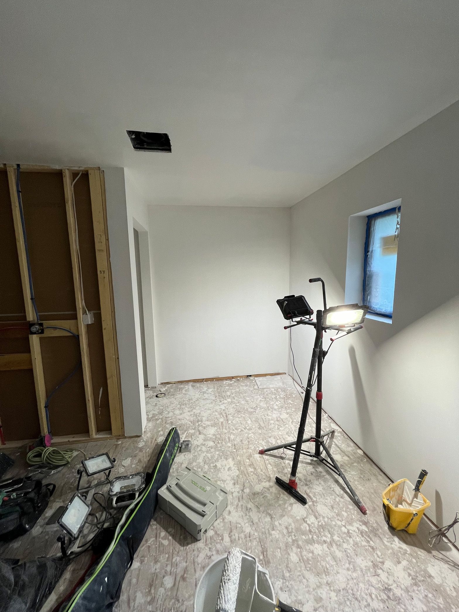 A room that is being remodeled with a light and a window.
