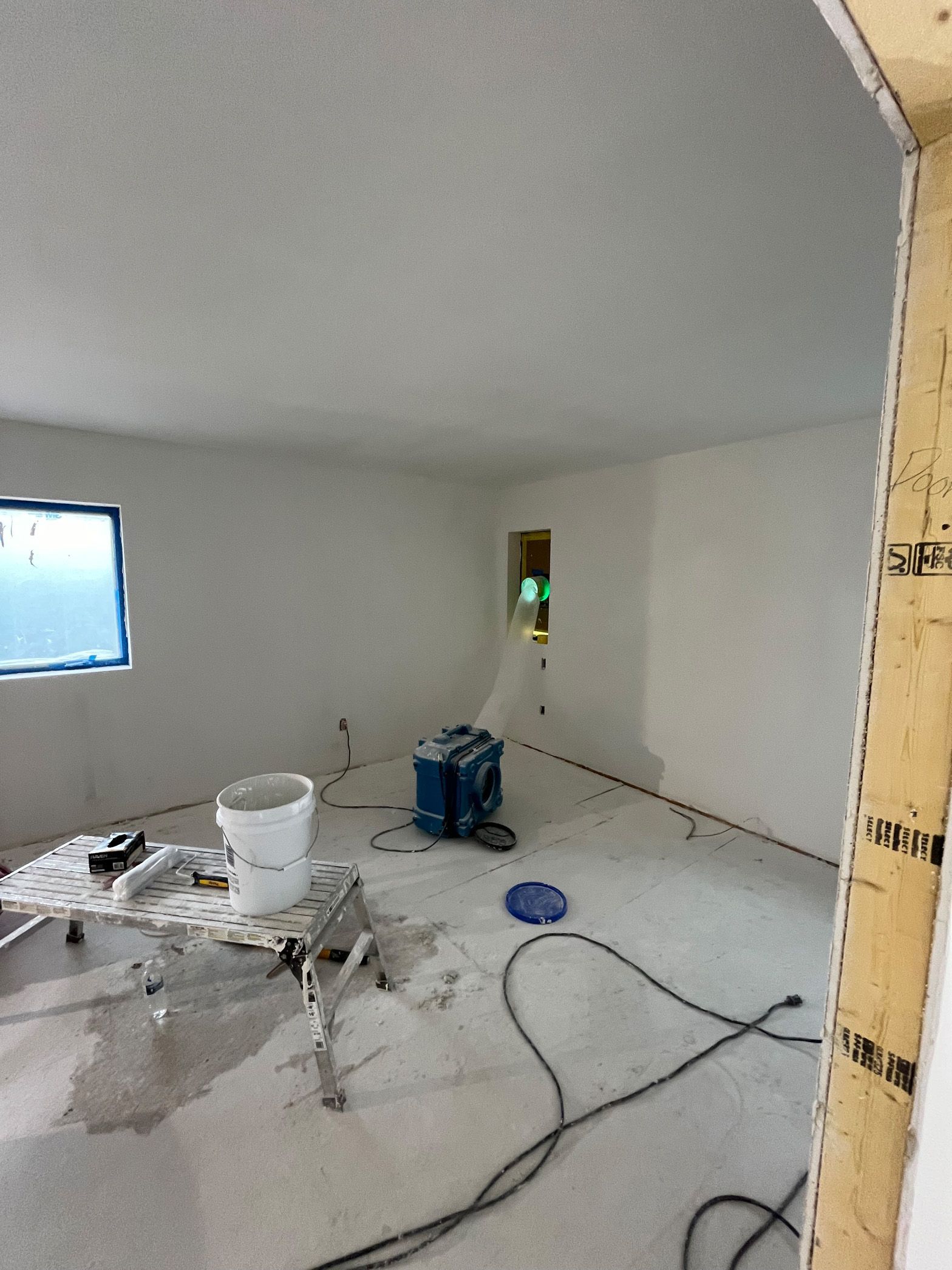 A room with white walls and a vacuum cleaner on the floor.