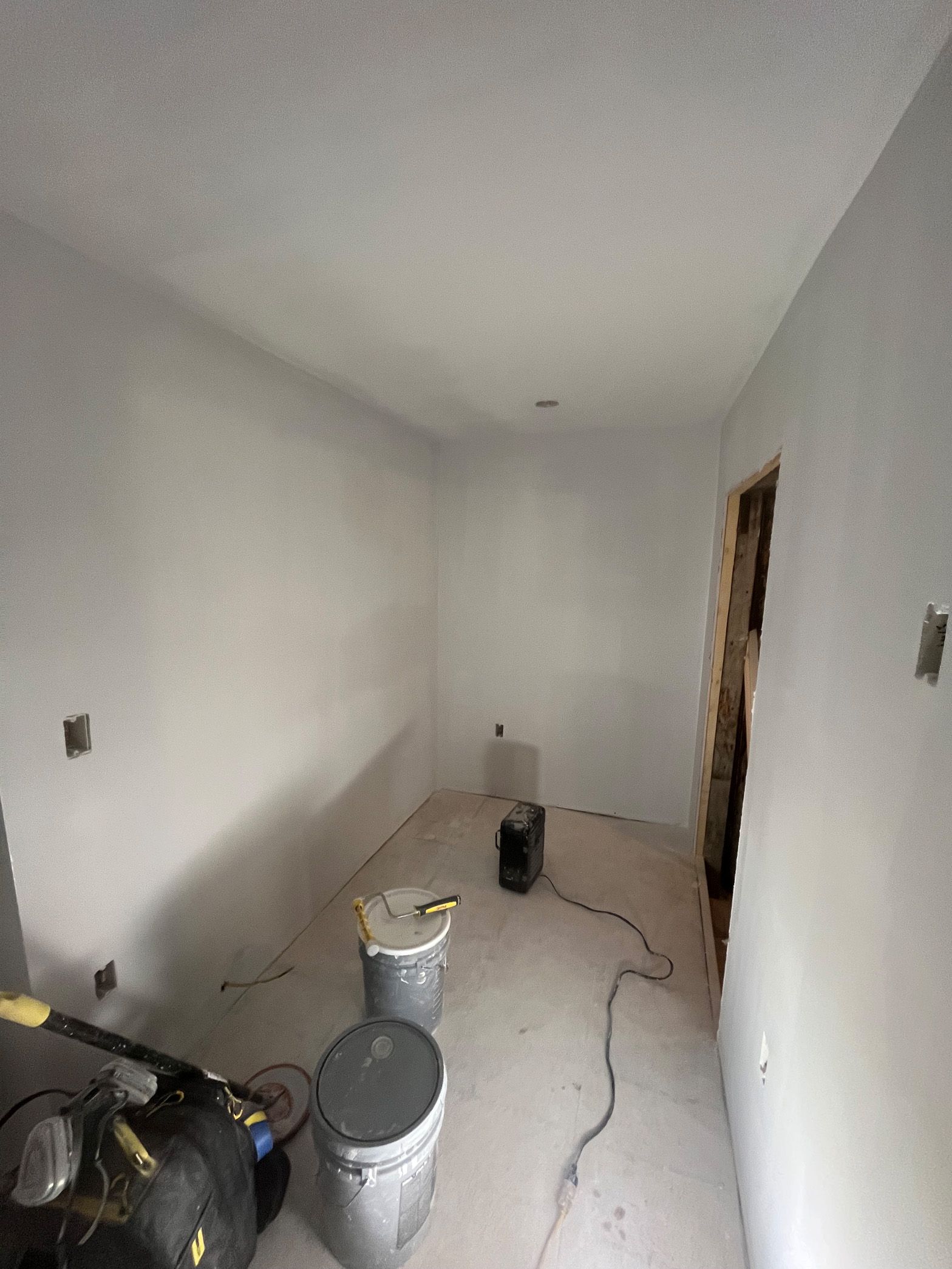 A room with white walls and a toilet in it.