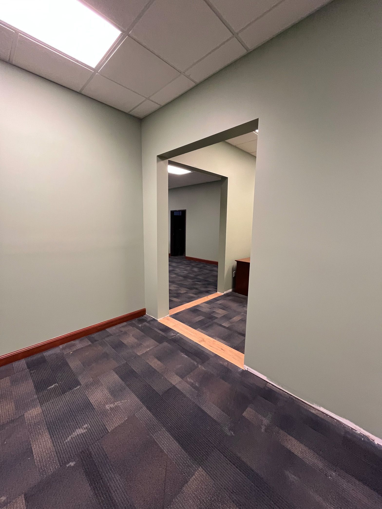 An empty room with a doorway leading to another room.