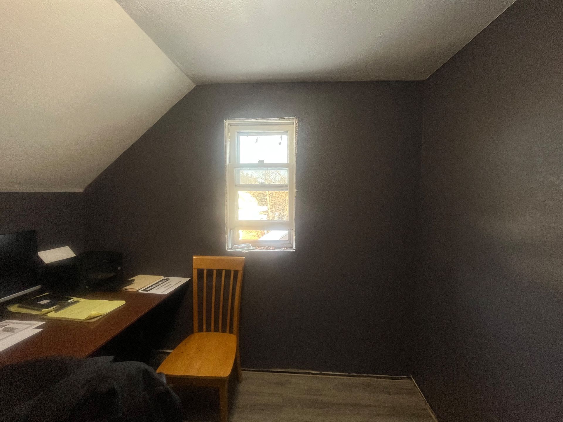 A room with a desk and chair and a window