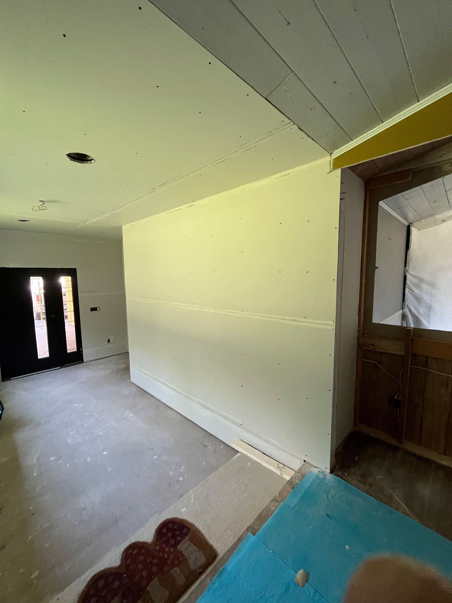 An empty room with a door and a white wall