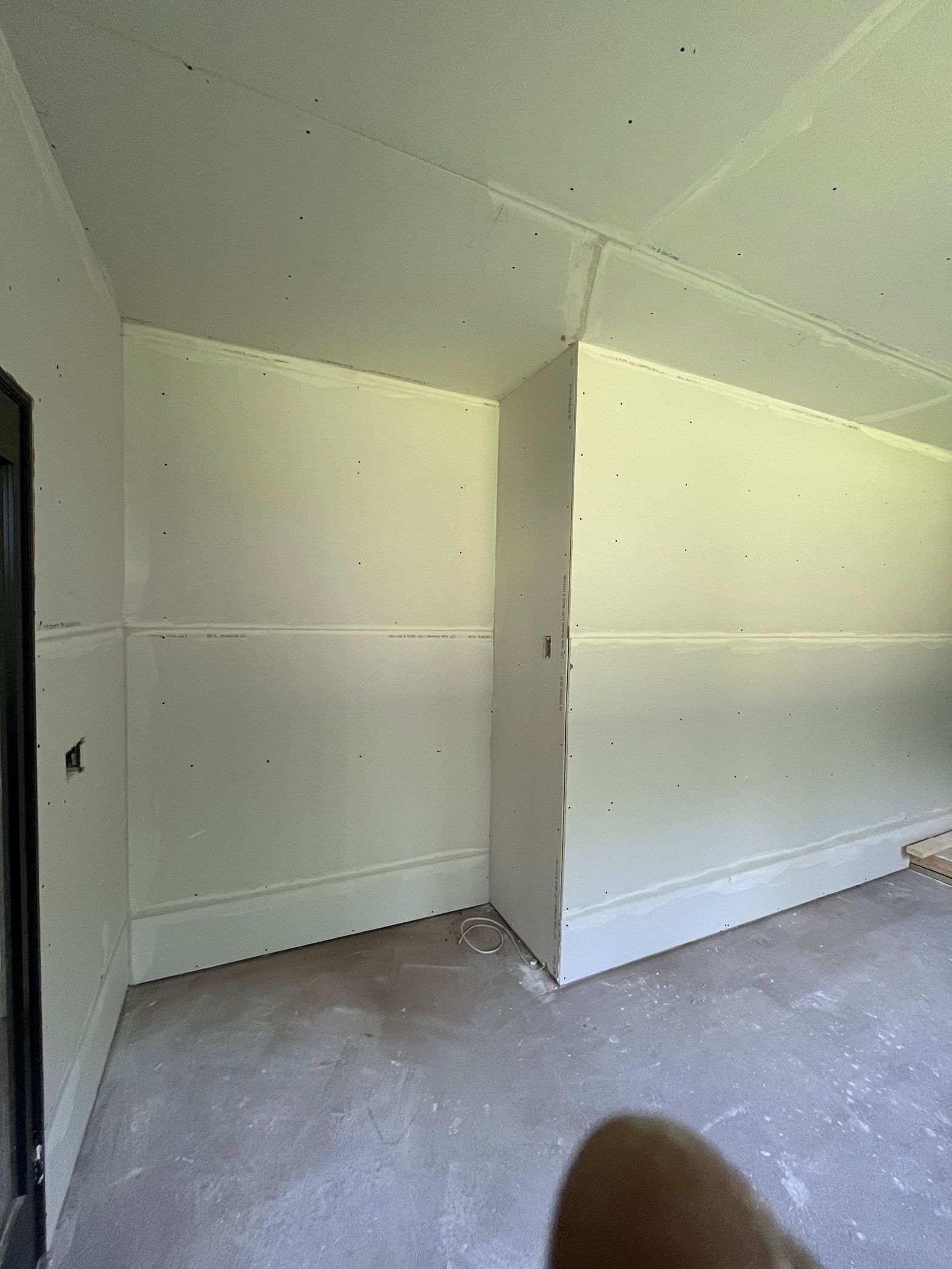 An empty room with white walls and a door.