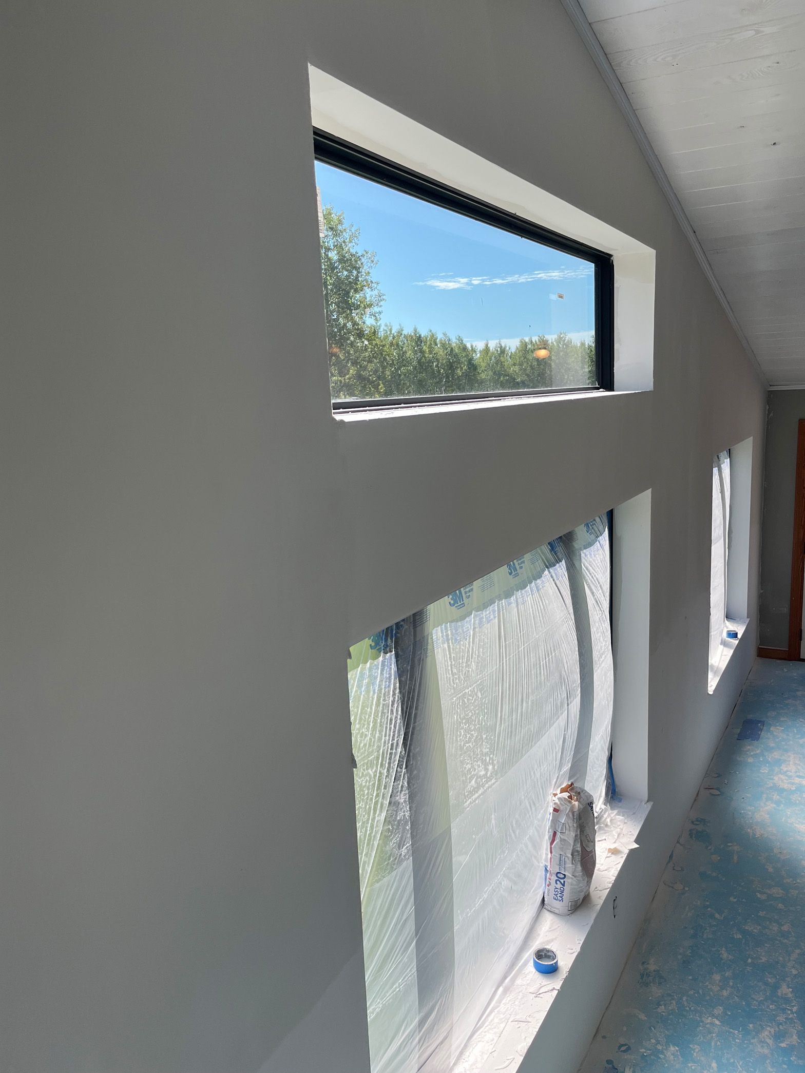 A hallway with a lot of windows and a statue on the window sill.