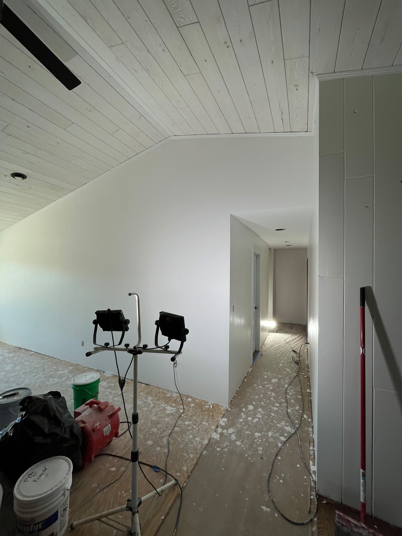 A room with white walls and a broom on the floor