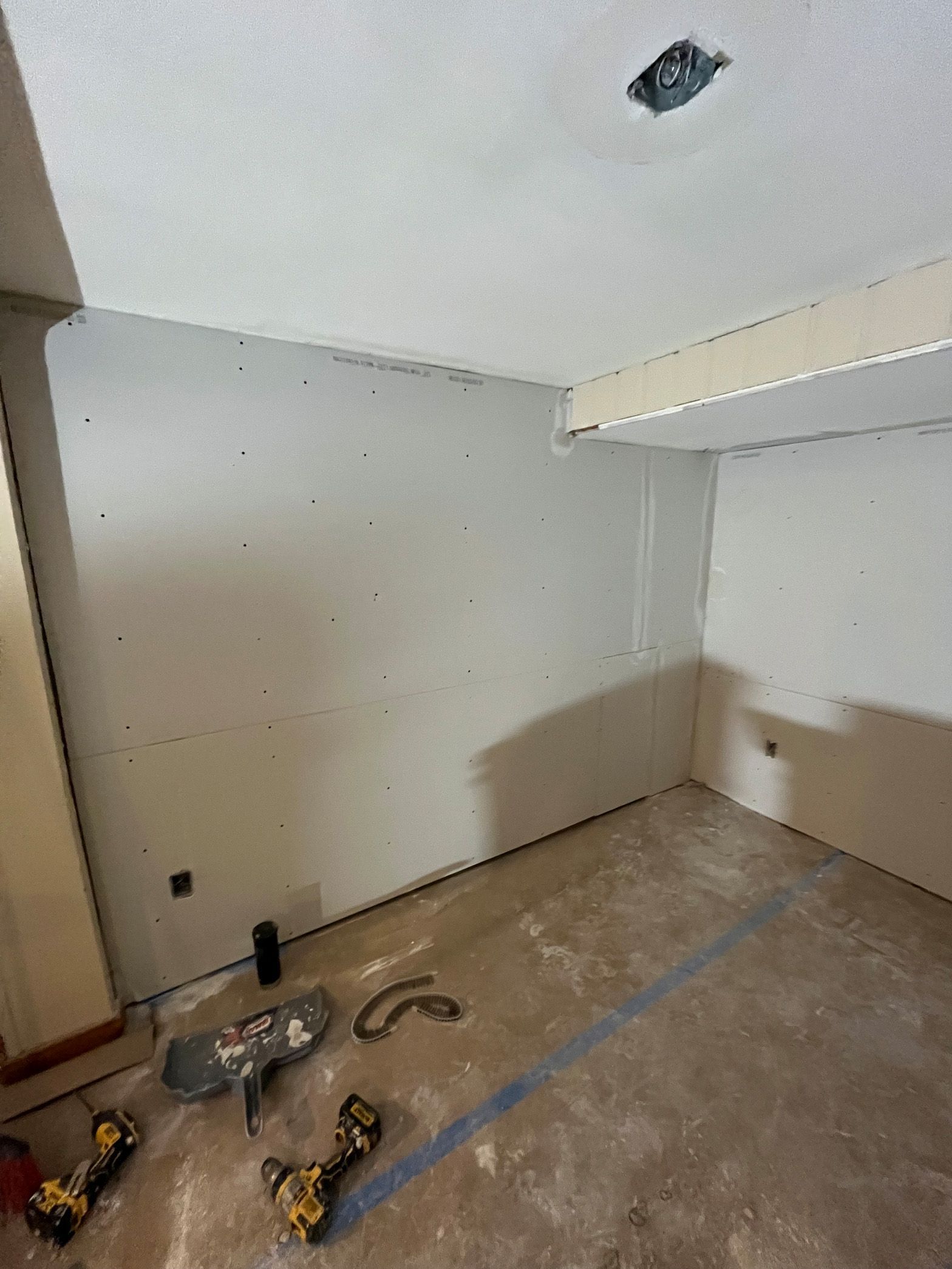 A room with a ceiling that is being remodeled with tools on the floor.