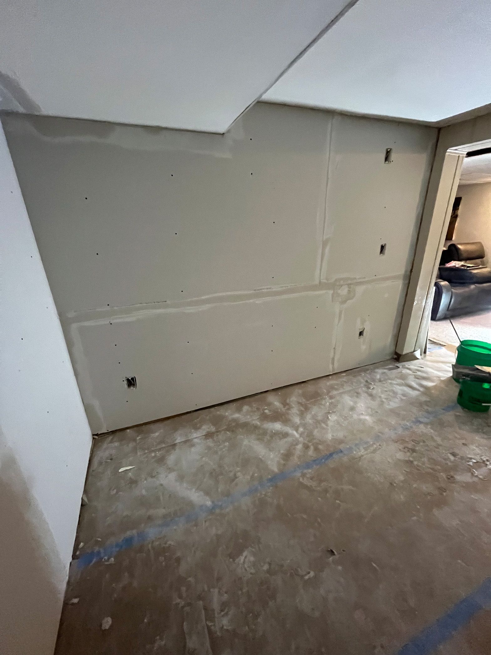 A corner of a room with a wall and a door.