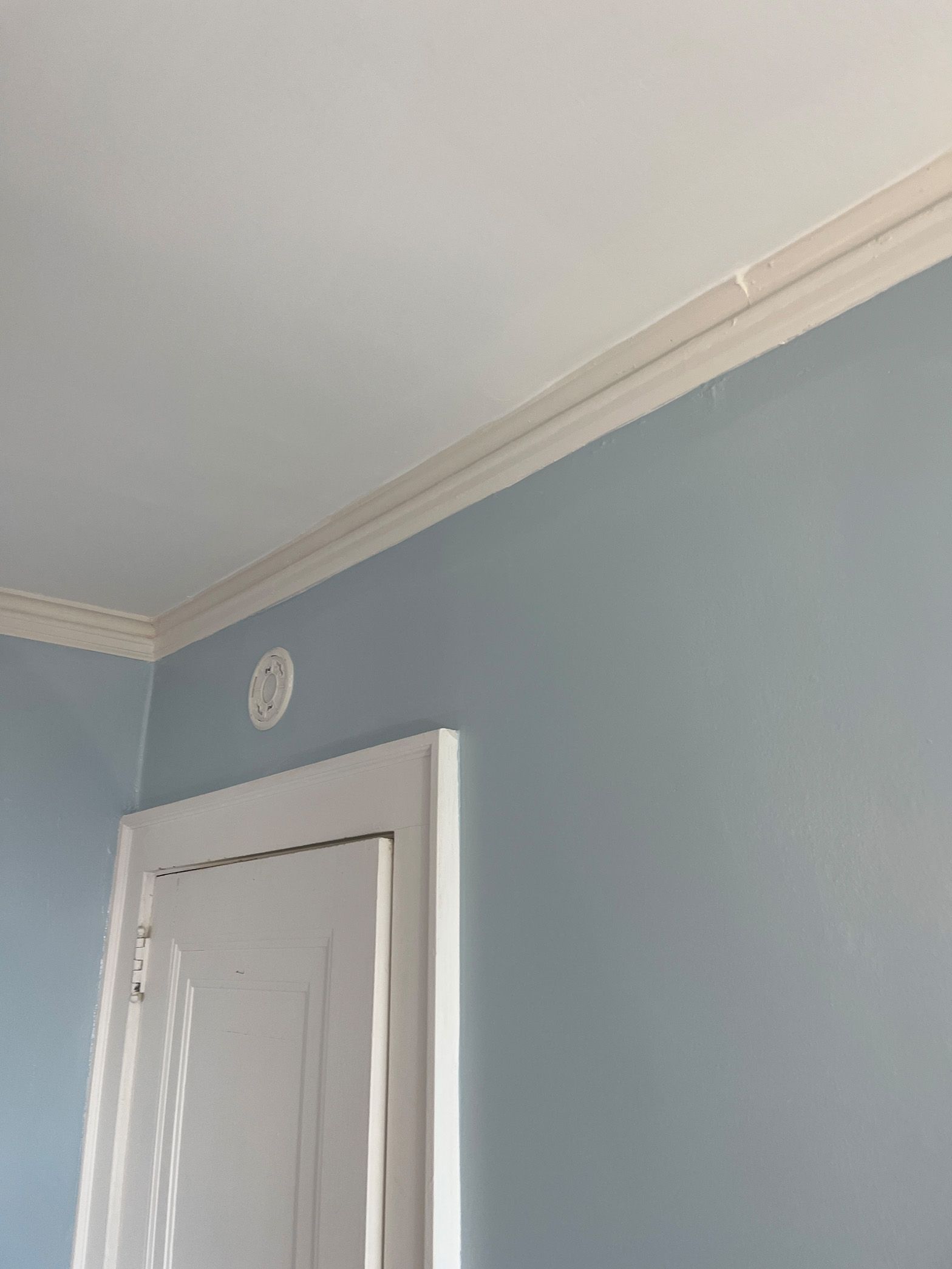 A room with blue walls and white trim and a white door.