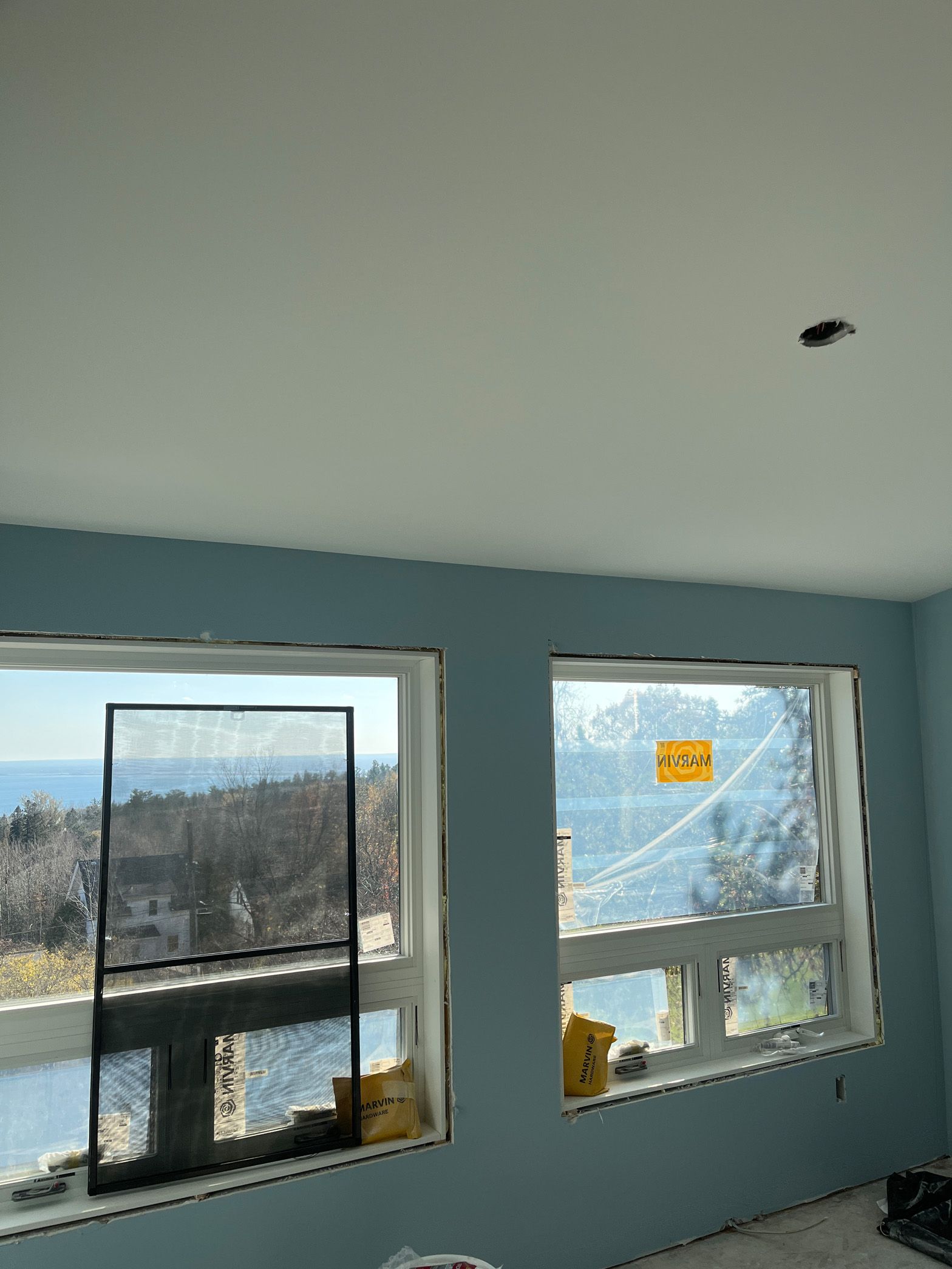 A room with a lot of windows and a view of the ocean.