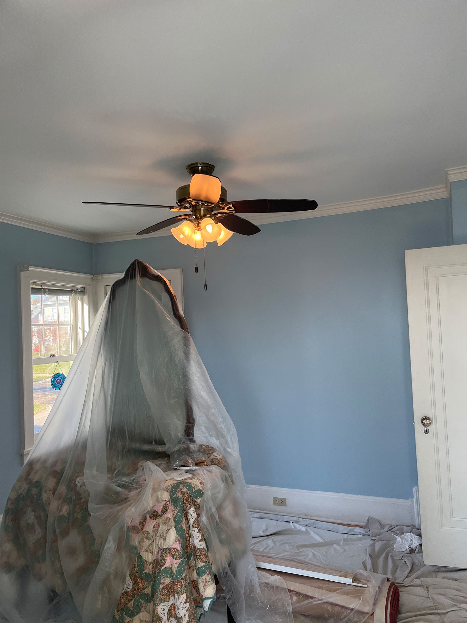 A room with blue walls and a ceiling fan.