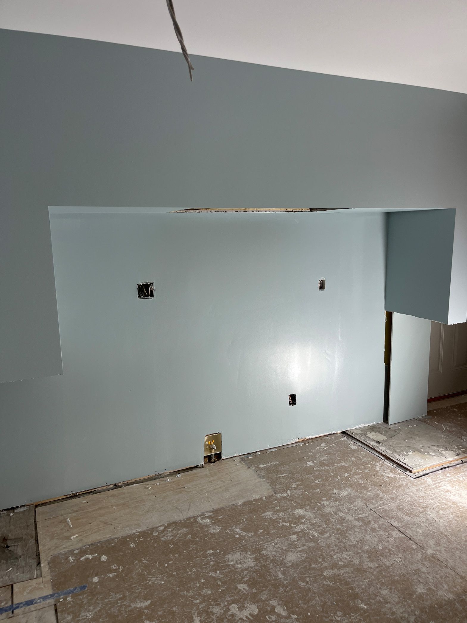 A room with a wall that is being painted.