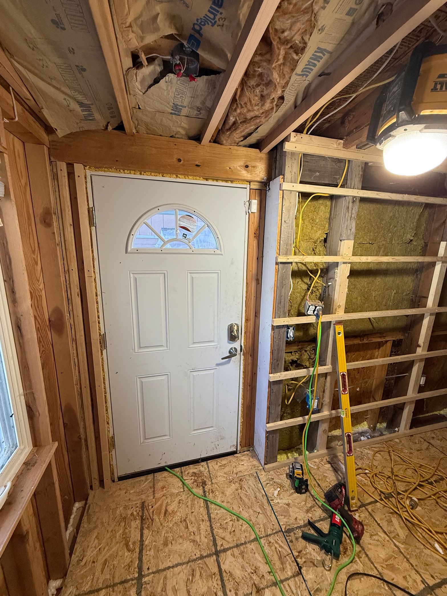 A room with a door and a ceiling fan in it.