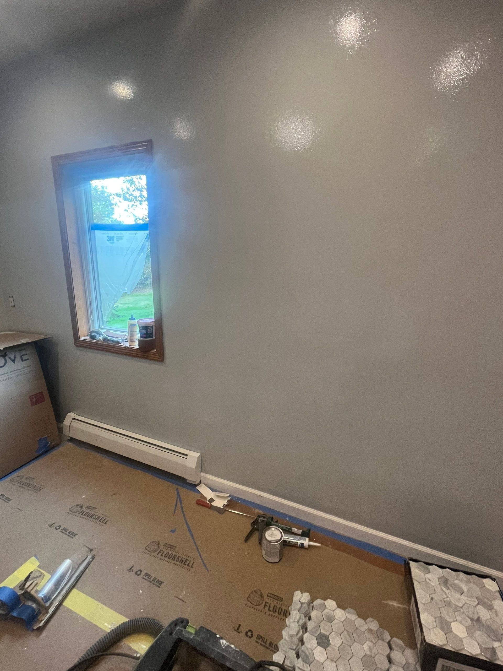 A room with a window and a vacuum cleaner on the floor.