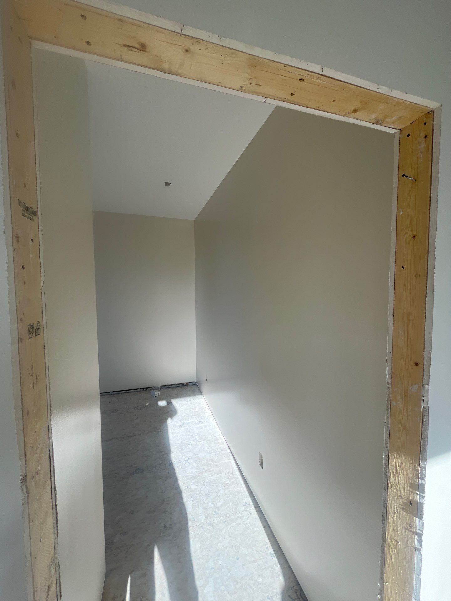 A room with white walls and a wooden frame