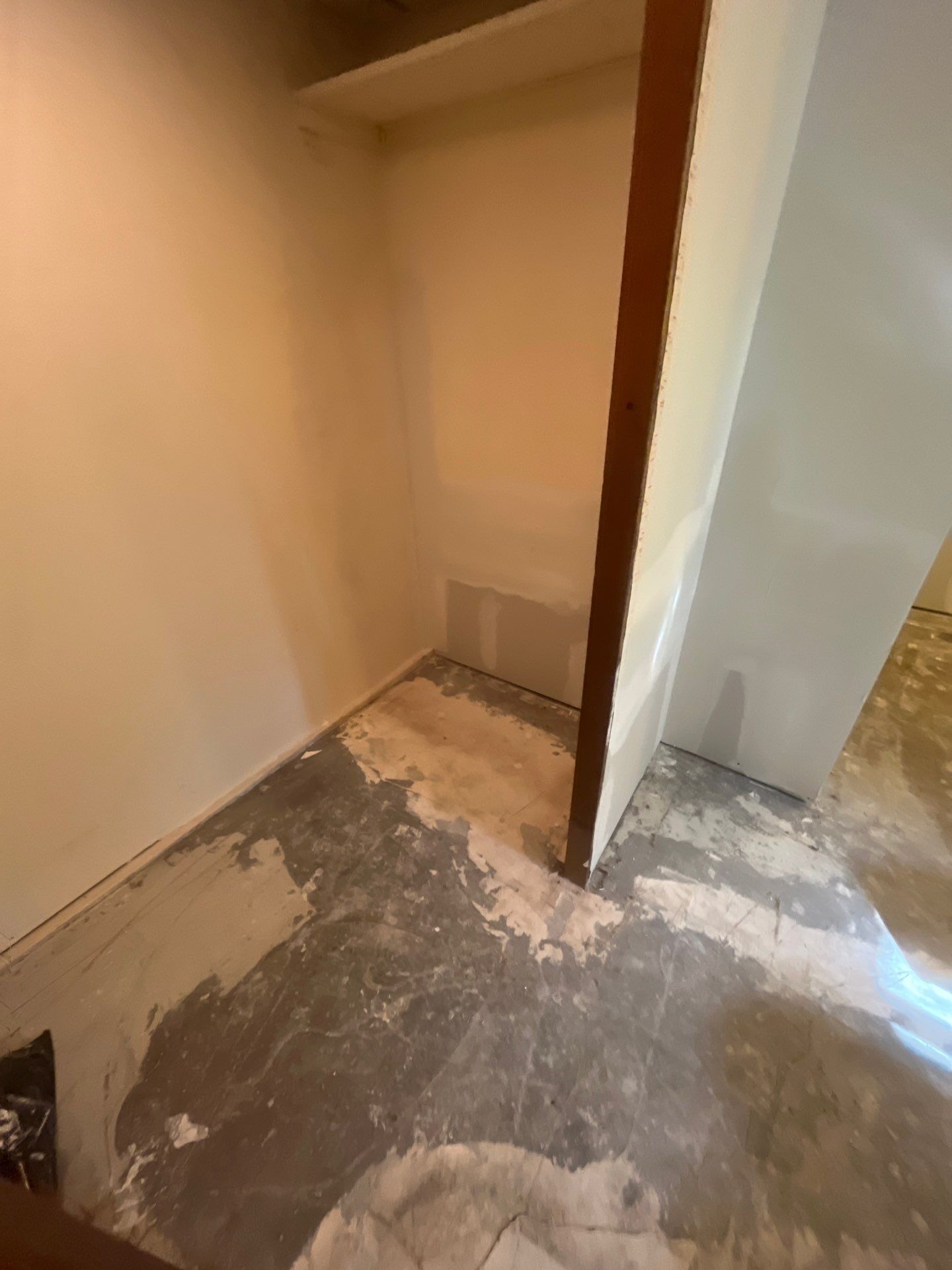 A room with a concrete floor and a wooden door.