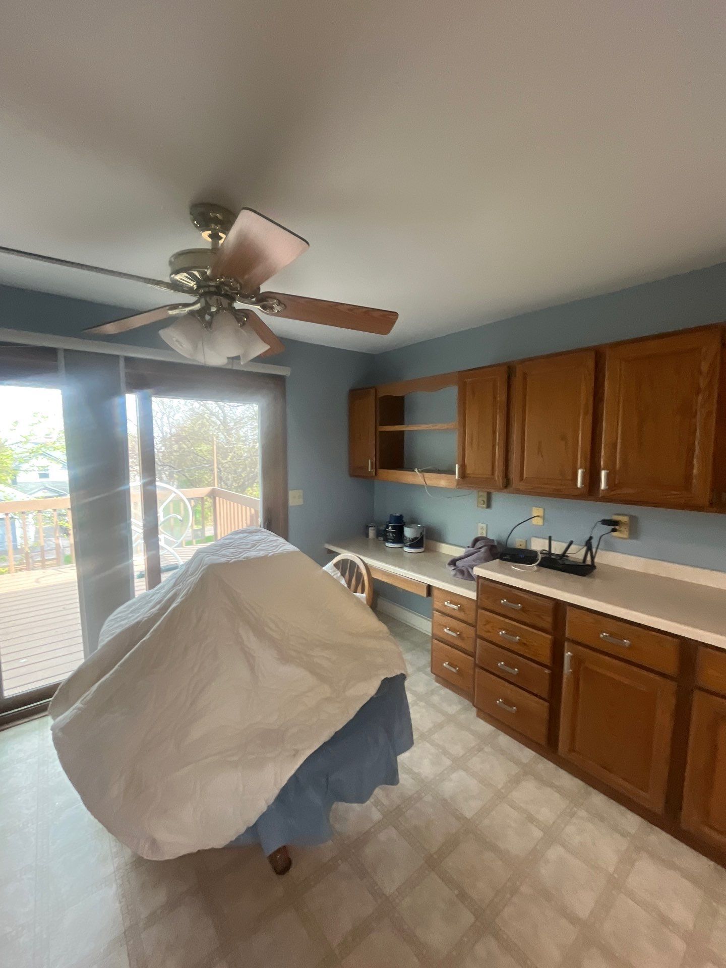 A kitchen with wooden cabinets and a ceiling fan.