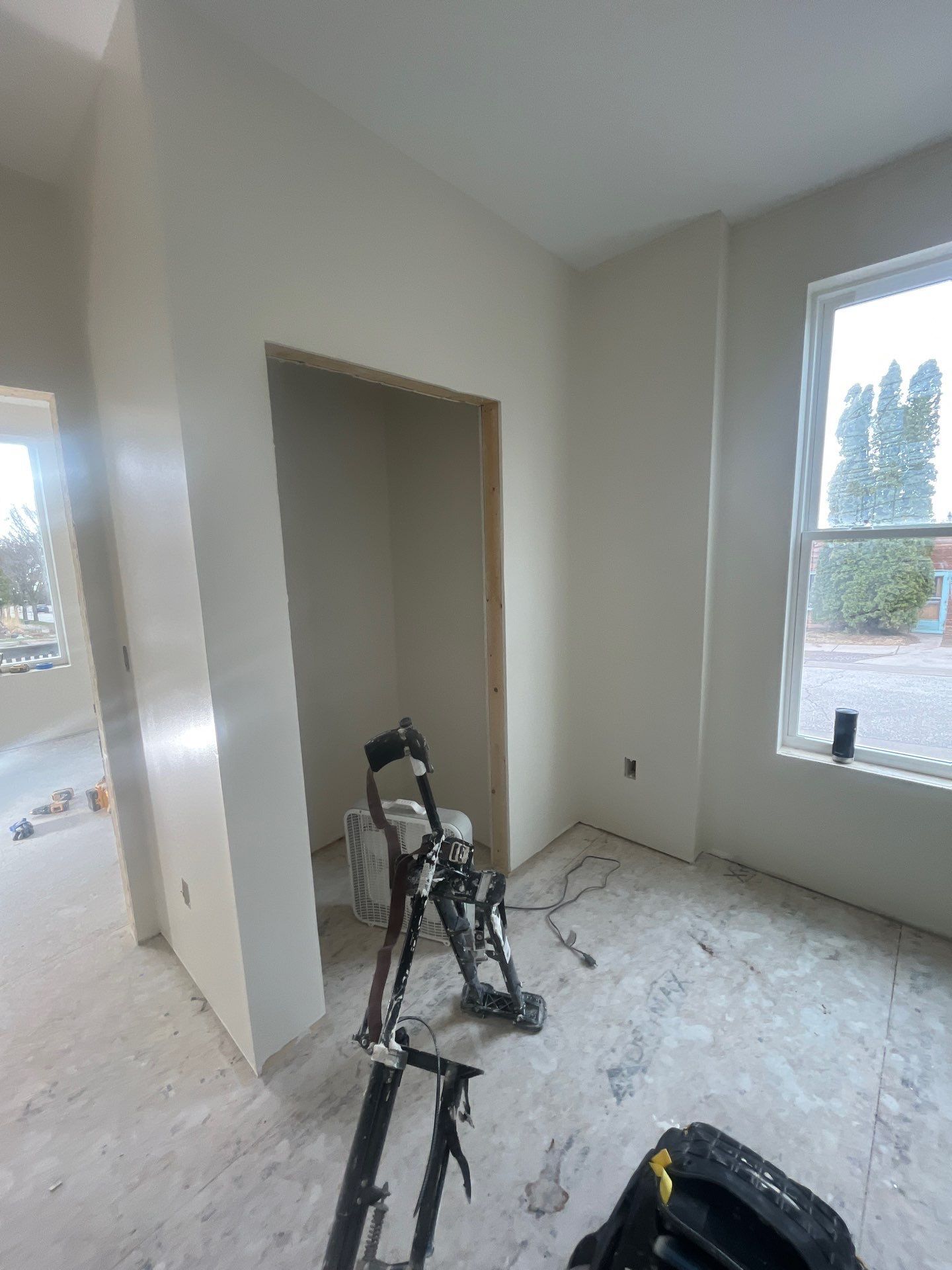 A room with a window and a ladder in it.