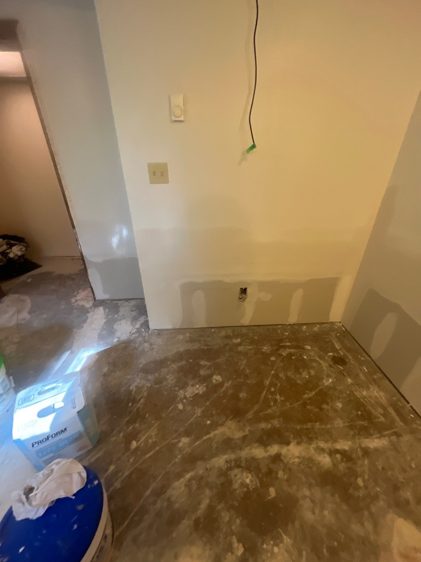 A room with a concrete floor and a white wall.