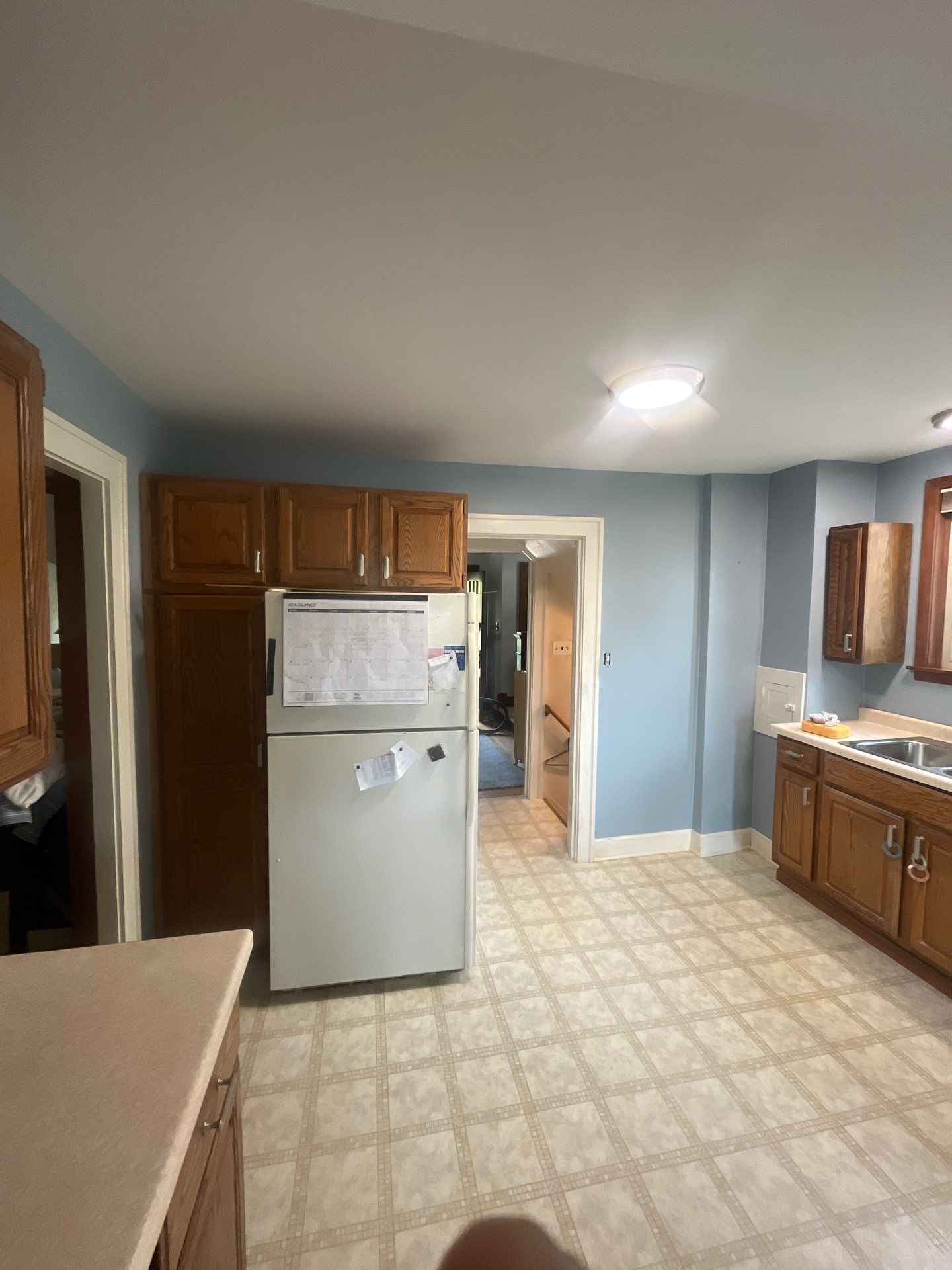 A kitchen with a refrigerator , sink , and cabinets.