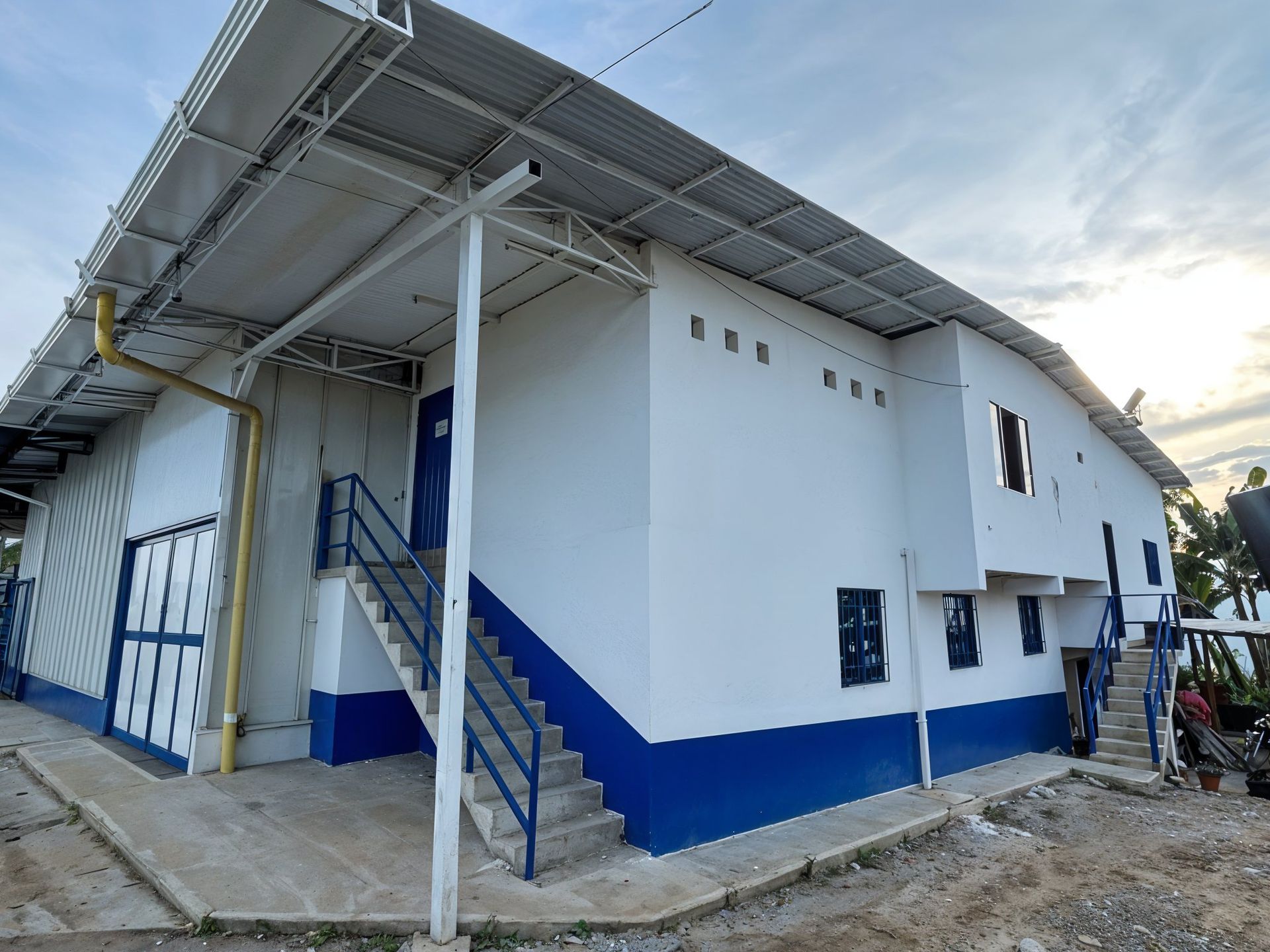 Un edificio blanco y azul con escaleras que conducen a él.