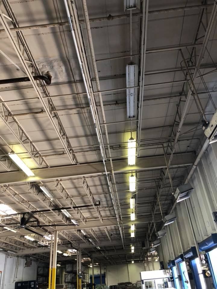 A large warehouse with a lot of lights hanging from the ceiling.