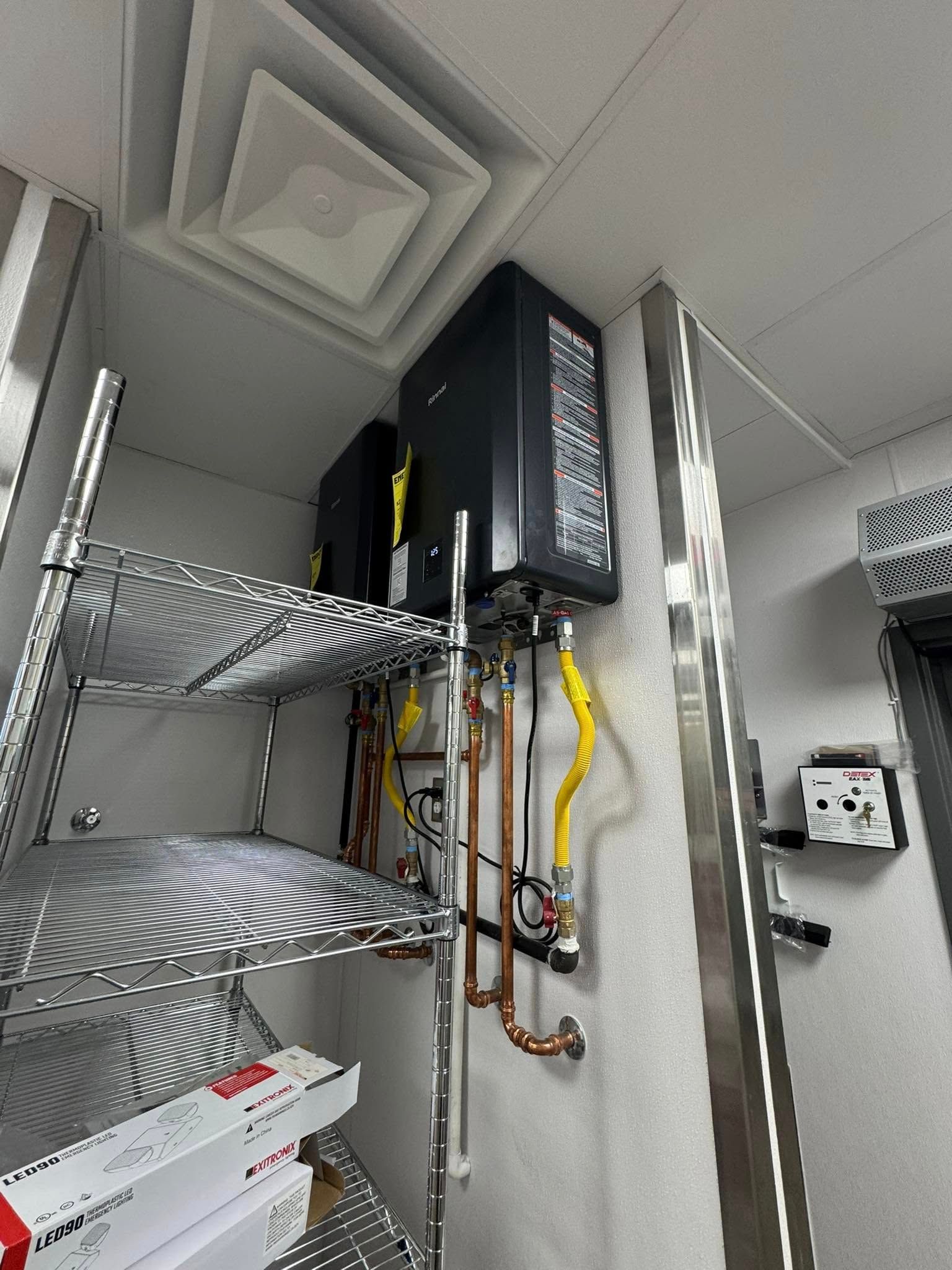 A person is holding a pressure gauge in front of a building.