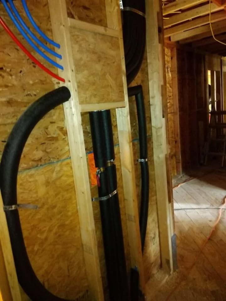 A bunch of pipes are hanging from a wooden wall