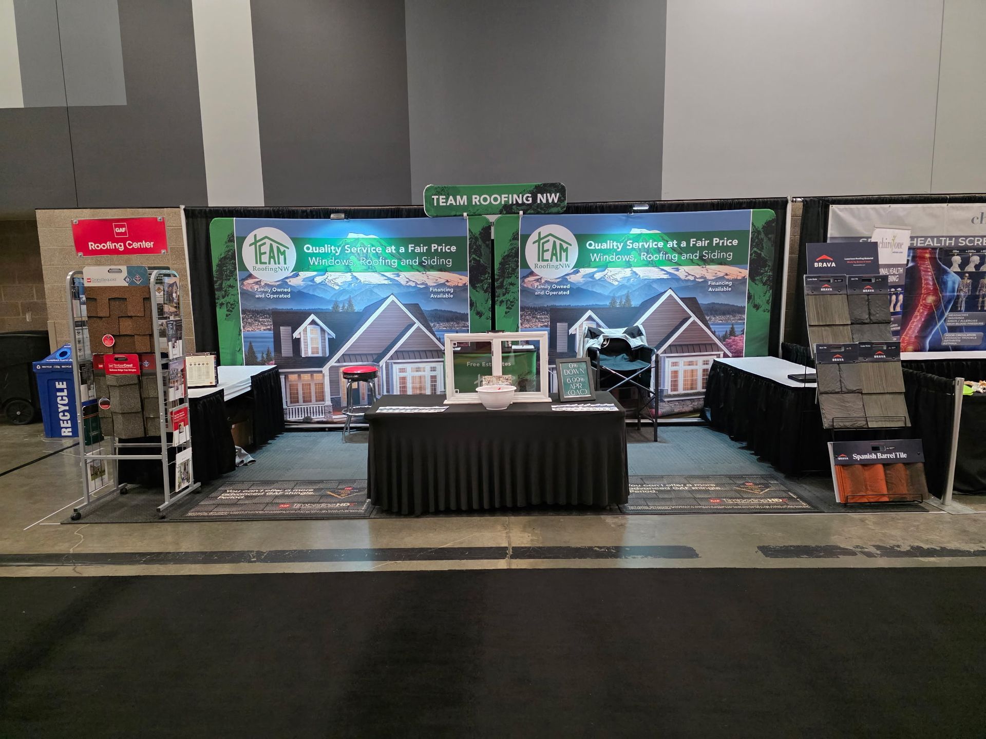 Trade show booth with window and roof displays and promotional banners.